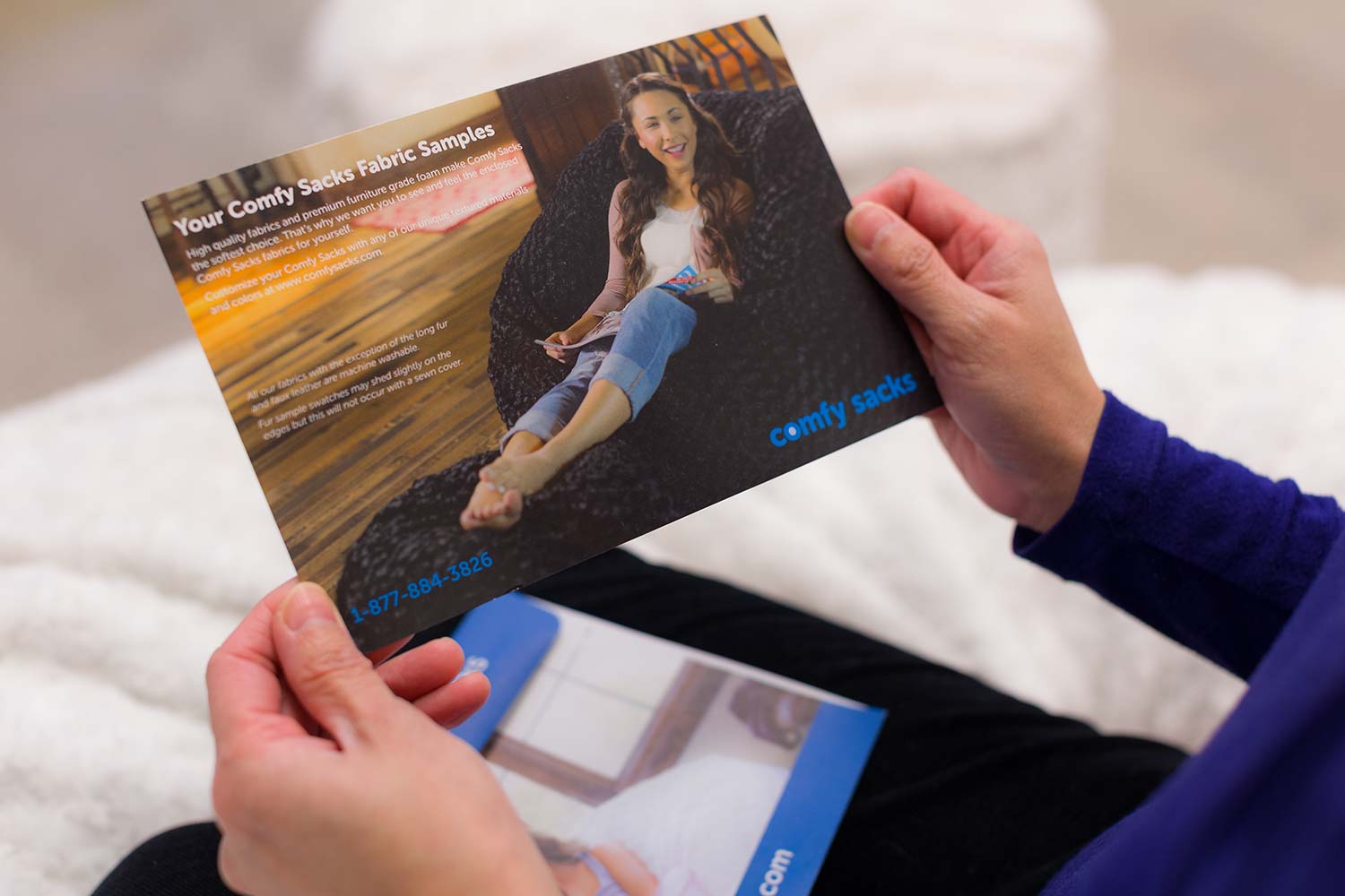 An close up of someone holding on to a Comfy Sacks post card