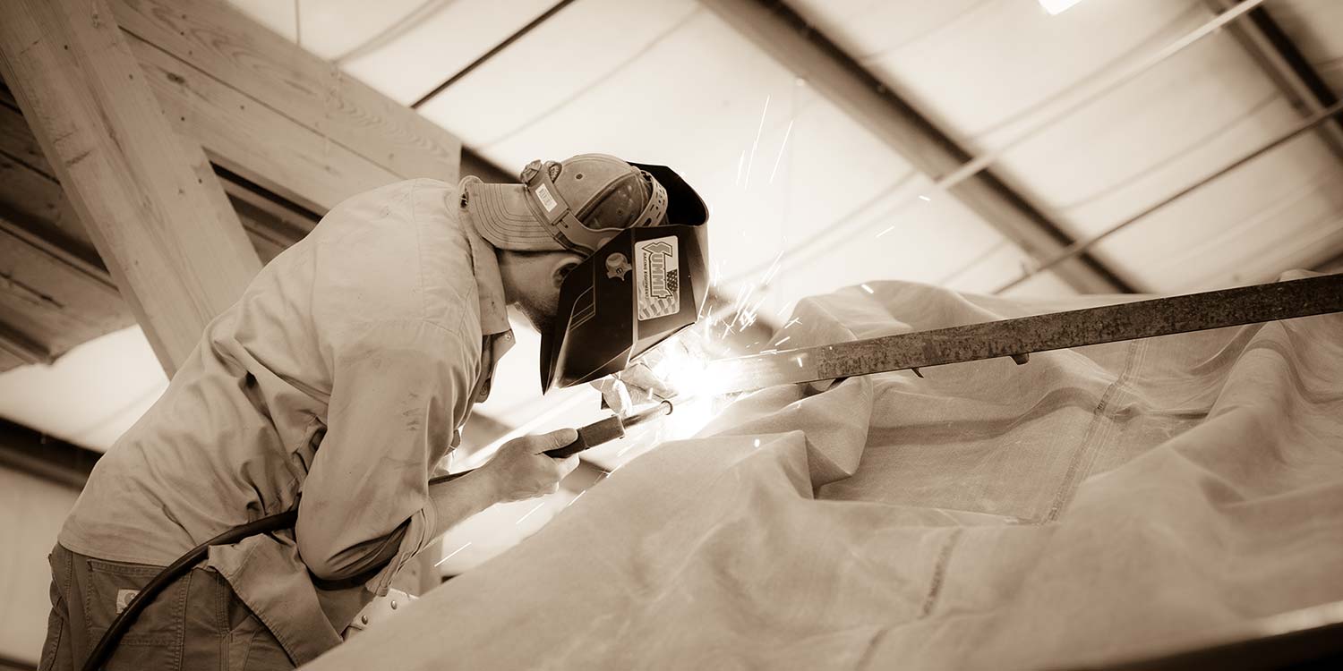 An image of a Kstair worker welding together a couple pieces of metal for a staircase